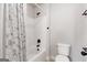 Clean bathroom with a shower and a toilet, accented with dark fixtures and a patterned shower curtain at 2307 Loughridge Dr, Buford, GA 30519