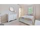 Bright bedroom featuring a white dresser, decorative mirror, and cozy bedding with a window at 2307 Loughridge Dr, Buford, GA 30519