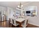 Elegant dining room with modern lighting, stainless steel refrigerator, and views to the living room at 2307 Loughridge Dr, Buford, GA 30519
