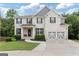 Charming two-story brick home featuring a well-manicured lawn, a two-car garage, and black shutters at 2307 Loughridge Dr, Buford, GA 30519