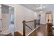 Upstairs hallway featuring hardwood floors and wooden railing, leading to bedrooms at 2307 Loughridge Dr, Buford, GA 30519