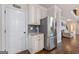 Kitchen area with stainless steel refrigerator, white cabinets and view to upper floor at 2307 Loughridge Dr, Buford, GA 30519