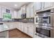 A well-equipped kitchen with white cabinetry, stainless appliances, granite countertops, and a tiled backsplash at 2307 Loughridge Dr, Buford, GA 30519