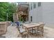 Relaxing outdoor patio with stone pavers, dining table, chairs, and a cozy fireplace for entertaining at 2307 Loughridge Dr, Buford, GA 30519