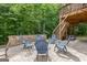 Outdoor patio with stone bench seating, blue chairs, stairs to an upper deck and a wooded view at 2307 Loughridge Dr, Buford, GA 30519