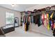 Walk-in closet featuring an installed rack with multiple clothing items, paired with an ottoman at 2307 Loughridge Dr, Buford, GA 30519
