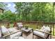 Relaxing back deck featuring cushioned seating, a decorative plant, and views of the lush backyard at 15 Stonewood Way, Sharpsburg, GA 30277