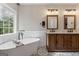 Bright primary bathroom with a soaking tub, patterned tile floor, and double sink vanity at 15 Stonewood Way, Sharpsburg, GA 30277