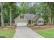 Charming home featuring a well-manicured lawn, inviting curb appeal, and attached two car garage at 15 Stonewood Way, Sharpsburg, GA 30277