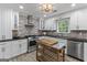 Bright kitchen features white cabinets, black countertops, stainless steel appliances, and a brick backsplash at 15 Stonewood Way, Sharpsburg, GA 30277