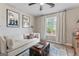 Cozy living room featuring a comfortable sofa, stylish decor, and natural light from the window at 15 Stonewood Way, Sharpsburg, GA 30277