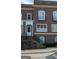 Close-up of the brick townhome featuring black iron details and a raised entrance, enhancing the property's curb appeal at 5139 Peachtree Road, Chamblee, GA 30341