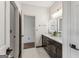 Modern bathroom with double vanity, dark wood cabinets, marble countertops, and contemporary lighting fixtures at 3835 Hickory Branch Trl, Suwanee, GA 30024