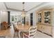 Bright dining room features modern chandelier, hardwood floors, and a charming china cabinet at 3835 Hickory Branch Trl, Suwanee, GA 30024