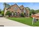 Beautiful two-story brick home with well-manicured lawn and mature trees at 3835 Hickory Branch Trl, Suwanee, GA 30024