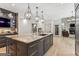Modern kitchen with a large island, dark cabinetry, stainless steel appliances, and stylish pendant lighting throughout at 3835 Hickory Branch Trl, Suwanee, GA 30024