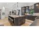 Modern kitchen features a large island with seating, dark cabinets, stainless steel appliances, and stylish pendant lighting at 3835 Hickory Branch Trl, Suwanee, GA 30024