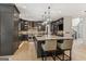 Modern kitchen boasts dark cabinetry, stainless steel appliances, a large island with seating, and stylish pendant lighting at 3835 Hickory Branch Trl, Suwanee, GA 30024