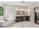Luxurious bathroom featuring a soaking tub, a large vanity, and a seamless transition to the main bedroom at 3835 Hickory Branch Trl, Suwanee, GA 30024