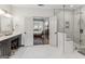 Bathroom with white tiled floors, double doors leading to bedroom, and a large tiled shower with a glass door at 3835 Hickory Branch Trl, Suwanee, GA 30024