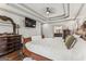 Spacious main bedroom features a tray ceiling, a ceiling fan, wood floors, and an ensuite bathroom at 3835 Hickory Branch Trl, Suwanee, GA 30024