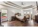 Large main bedroom with wood flooring, a ceiling fan, and an area with bay windows for relaxing at 3835 Hickory Branch Trl, Suwanee, GA 30024