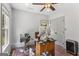 Well-lit home office with ample natural light, hardwood floors, and a ceiling fan for a comfortable work environment at 3835 Hickory Branch Trl, Suwanee, GA 30024