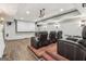 Basement theater room with tiered seating, projector, and hardwood floors at 3835 Hickory Branch Trl, Suwanee, GA 30024