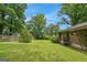 Expansive backyard featuring a well-maintained lawn and a privacy fence surrounded by mature trees at 4653 Ridgewood Dr, Forest Park, GA 30297