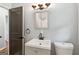 Bathroom view showcases a sink vanity, toilet, and framed mirror with light fixture at 4653 Ridgewood Dr, Forest Park, GA 30297