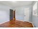 Bedroom showcasing hardwood floors, natural light, and a gray accent door at 4653 Ridgewood Dr, Forest Park, GA 30297