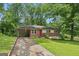 Single-story brick home with carport, green lawn, and mature trees; an inviting exterior at 4653 Ridgewood Dr, Forest Park, GA 30297