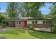 Charming single-story brick home with a red front door, covered parking, and a well-maintained lawn at 4653 Ridgewood Dr, Forest Park, GA 30297