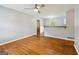 Spacious living room with hardwood floors, ceiling fan, and view of the kitchen and front entry at 4653 Ridgewood Dr, Forest Park, GA 30297