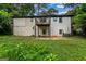 Home backyard view with overgrown grass, a deck, and a white brick exterior at 2835 Laguna Dr, Decatur, GA 30032