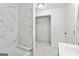 Bright bathroom showing tub with shower, marble tiling, vanity, and walk-in closet at 2835 Laguna Dr, Decatur, GA 30032