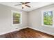 Bedroom featuring hardwood floors, a ceiling fan, and two windows overlooking the yard at 2835 Laguna Dr, Decatur, GA 30032