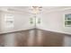Large bedroom with hardwood floors, neutral paint, a trey ceiling and natural light from three windows at 8041 Louis Dr, Locust Grove, GA 30248