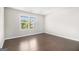 Bedroom with hardwood floors, neutral paint, and natural light coming from a large window at 8041 Louis Dr, Locust Grove, GA 30248