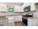 Bright kitchen featuring stainless steel appliances, granite countertops, wooden floors and white cabinets at 8041 Louis Dr, Locust Grove, GA 30248