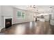 Open-concept living room with fireplace, hardwood floors, white trim, and an adjacent kitchen at 8041 Louis Dr, Locust Grove, GA 30248