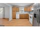 Functional kitchen featuring wood cabinetry, white appliances, laminate countertops and durable wood-look flooring at 465 Haynie Rd, Moreland, GA 30259