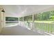A covered porch featuring white railings and views of the surrounding trees and well-manicured lawn at 465 Haynie Rd, Moreland, GA 30259
