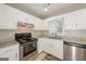 Well-lit kitchen featuring white cabinets, stainless steel appliances, and granite countertops at 2090 Blackberry Ln, Auburn, GA 30011