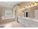 Bright bathroom featuring double vanity, tub, enclosed shower, and tile flooring at 917 Saints Ct, Marietta, GA 30068