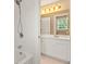 Bright bathroom with tiled shower and white vanity with decorative lighting at 917 Saints Ct, Marietta, GA 30068