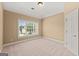 A bright bedroom boasts neutral walls and carpet, and features a window with neighborhood views at 917 Saints Ct, Marietta, GA 30068