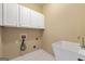 Laundry room with white cabinetry, utility sink, and washer and dryer hookups at 917 Saints Ct, Marietta, GA 30068