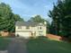 Charming split-level home with a well-maintained lawn and a two-car garage, surrounded by mature trees at 135 Green Commons Dr, Covington, GA 30016