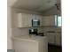 Modern kitchen featuring white cabinets, quartz countertops, and stainless steel appliances at 135 Green Commons Dr, Covington, GA 30016